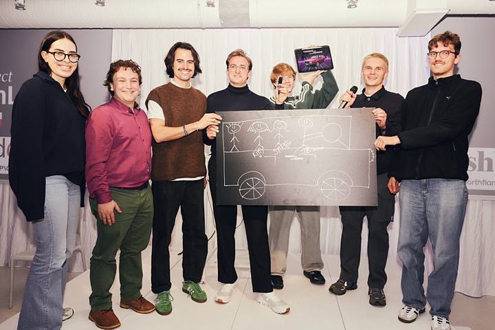 Joël Hainzl, center in a black turtleneck, with his team holding a drawn car board and the VW Jetta key on stage at the Project Europe hackathon with ElevenLabs in Warsaw